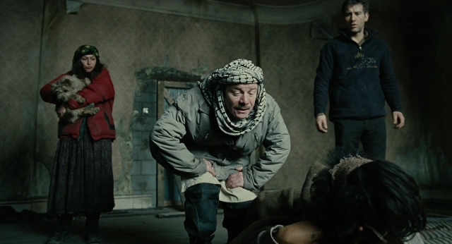 Wide shot frame from Children of Men — standing, room, dog