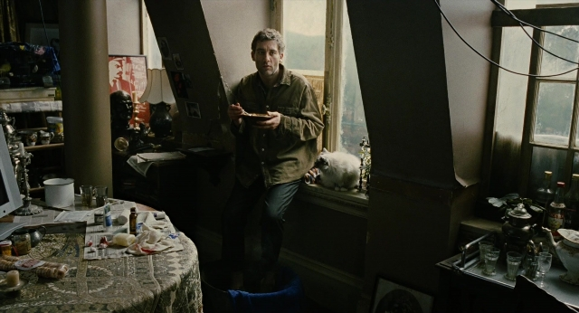 Wide shot frame from Children of Men — sitting, standing, room
