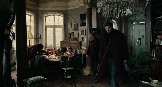 Wide shot frame from Children of Men — sitting, standing, room