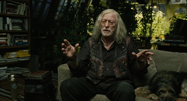 Wide shot frame from Children of Men — sitting, book, room