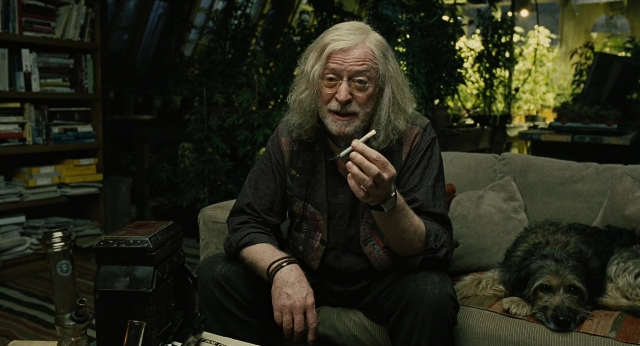 Wide shot frame from Children of Men — sitting, book, room