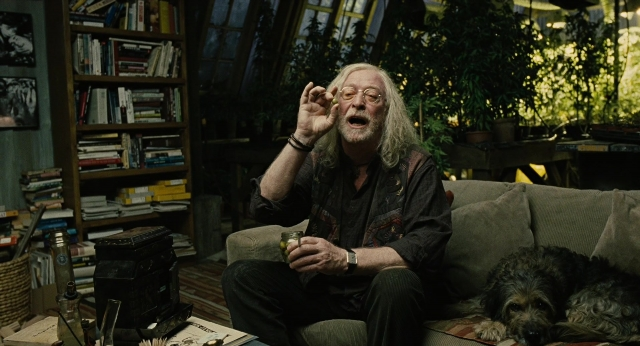 Wide shot frame from Children of Men — sitting, book, room