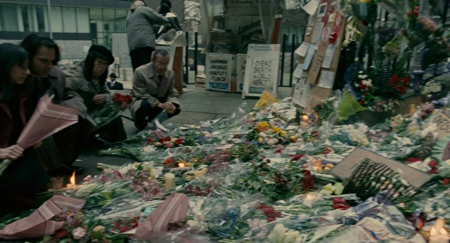 Wide shot frame from Children of Men — flower, person, human face