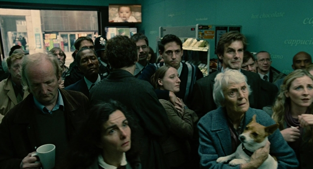 Wide shot frame from Children of Men — standing, room, dog