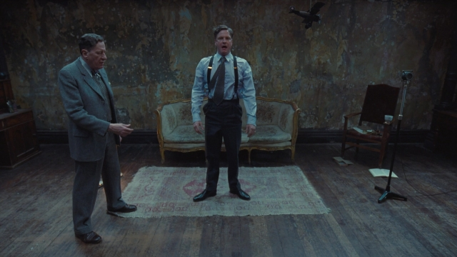 Wide shot frame from The King's Speech — standing, room, table