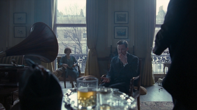 Wide shot frame from The King's Speech — sitting, book, room