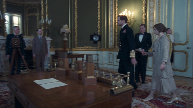 Wide shot frame from The King's Speech — standing, room, table