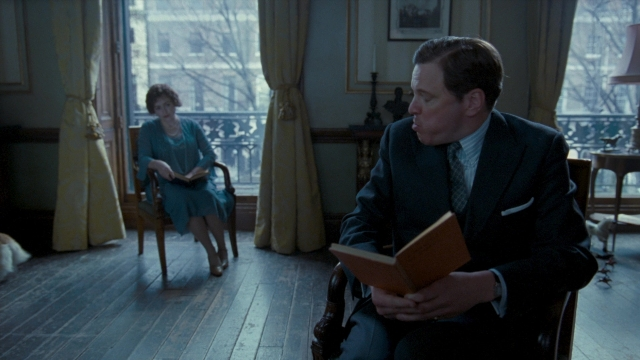 Wide shot frame from The King's Speech — sitting, book, room