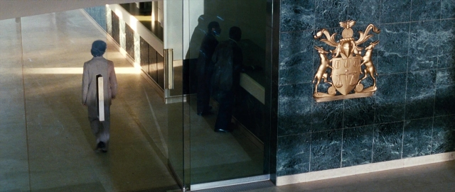 Wide shot frame from The Last King of Scotland — walking, door, coat