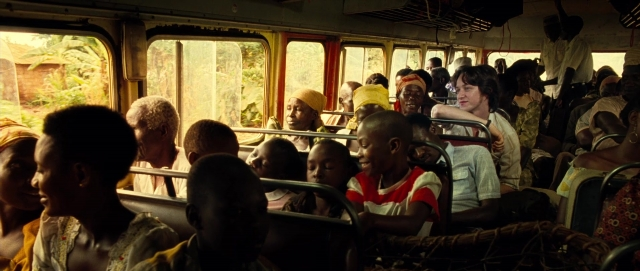 Wide shot frame from The Last King of Scotland — sitting, standing, bus
