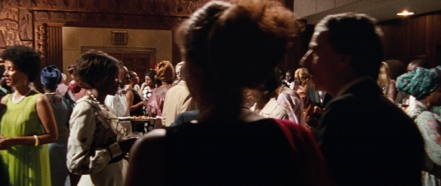 Wide shot frame from The Last King of Scotland — room, dialogue, dress