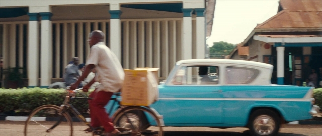 Wide shot frame from The Last King of Scotland — walking, street, car