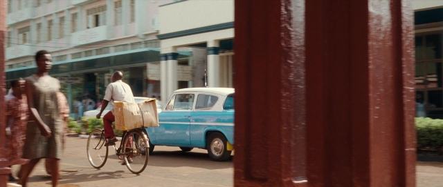 Wide shot frame from The Last King of Scotland — walking, street, car