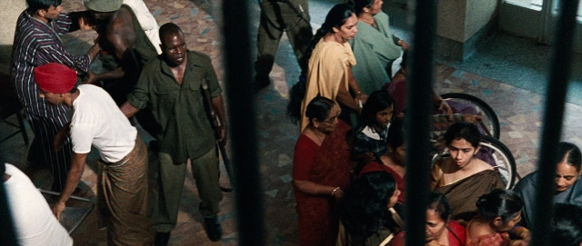 Medium shot frame from The Last King of Scotland — sitting, book, standing