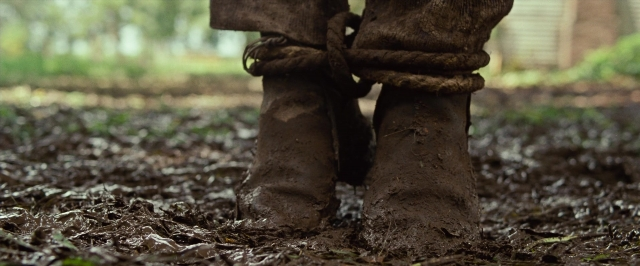 Wide shot frame from 12 Years a Slave — standing, bed, footwear