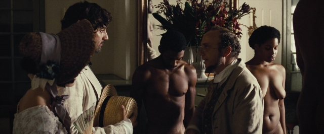 Wide shot frame from 12 Years a Slave — room, table, bed