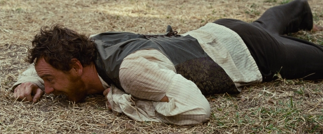 Wide shot frame from 12 Years a Slave — bed, shirt, person