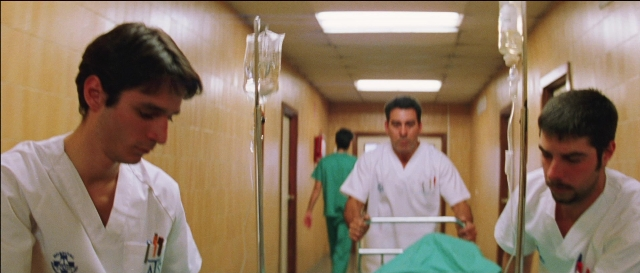 Wide shot frame from Todo sobre mi madre — standing, bed, door