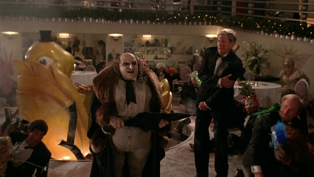 Wide shot frame from Batman Returns — standing, room, dialogue