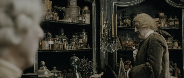 Wide shot frame from Perfume: The Story of a Murderer — standing, mirror, coat
