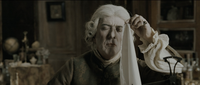 Wide shot frame from Perfume: The Story of a Murderer — table, coat, hand