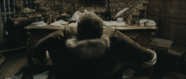 Wide shot frame from Perfume: The Story of a Murderer — sitting, room, suit