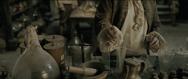 Wide shot frame from Perfume: The Story of a Murderer — standing, table, hand