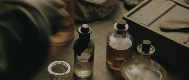 Frame from Perfume: The Story of a Murderer — table, bottle, glass