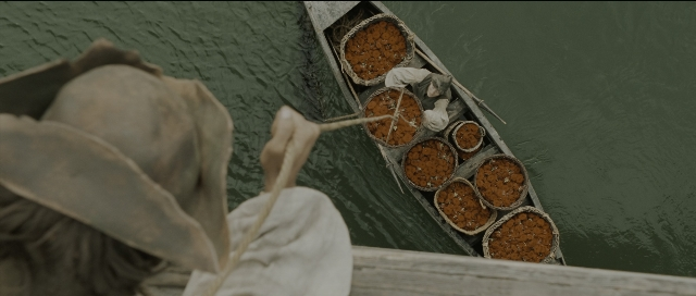 Wide shot frame from Perfume: The Story of a Murderer — standing, hat, food