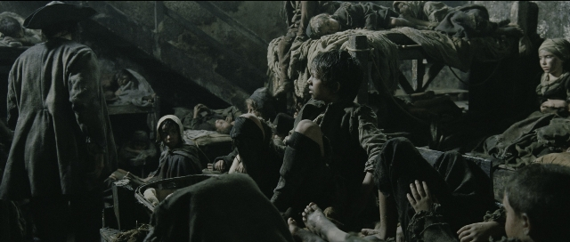 Wide shot frame from Perfume: The Story of a Murderer — sitting, standing, room