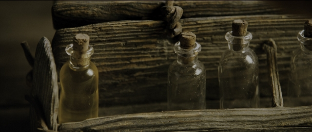 Wide shot frame from Perfume: The Story of a Murderer — table, bottle, glass