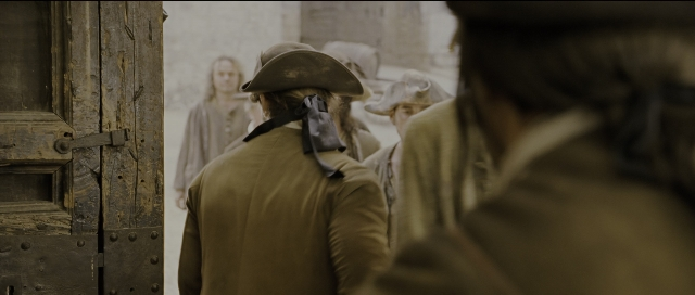 Wide shot frame from Perfume: The Story of a Murderer — standing, door, hat