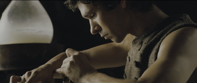 Wide shot frame from Perfume: The Story of a Murderer — sitting, table, shirt