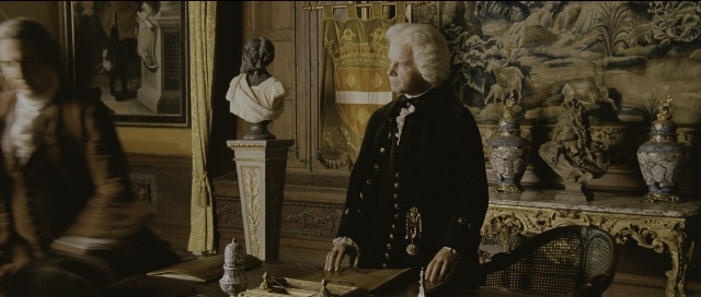 Wide shot frame from Perfume: The Story of a Murderer — sitting, book, room