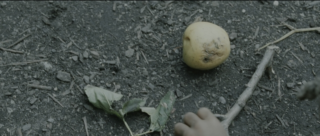 Wide shot frame from Perfume: The Story of a Murderer — hand, fruit, person