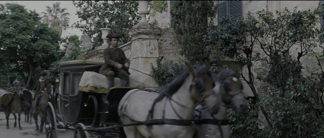 Wide shot frame from Perfume: The Story of a Murderer — sitting, street, hat