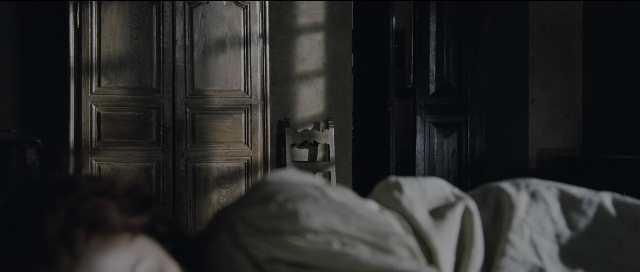 Wide shot frame from Perfume: The Story of a Murderer — room, bed, door