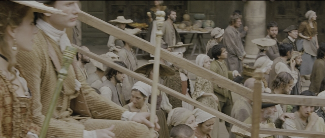 Wide shot frame from Perfume: The Story of a Murderer — standing, dialogue, hat