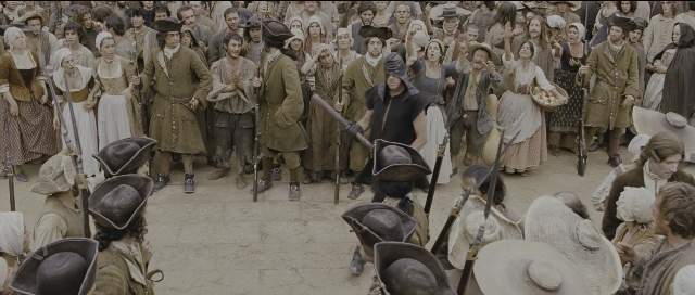 Wide shot frame from Perfume: The Story of a Murderer — standing, dialogue, hat