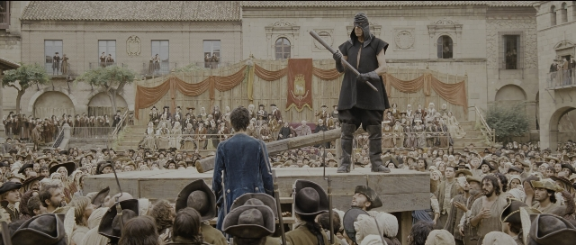 Wide shot frame from Perfume: The Story of a Murderer — standing, dialogue, hat