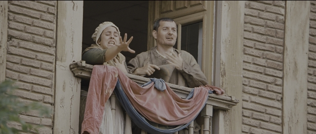 Wide shot frame from Perfume: The Story of a Murderer — sitting, dress, person