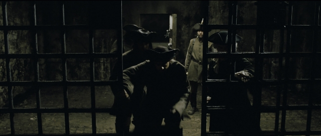Wide shot frame from Perfume: The Story of a Murderer — standing, room, gun