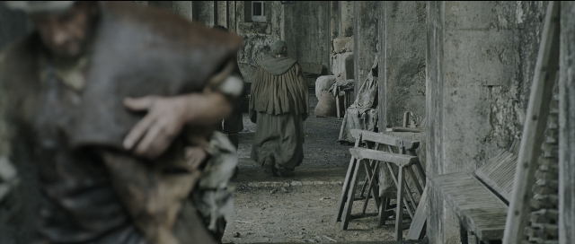Wide shot frame from Perfume: The Story of a Murderer — sitting, standing, hat