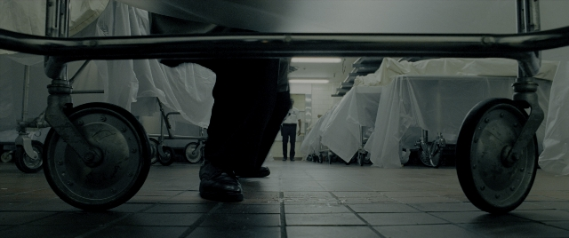 Wide shot frame from Constantine — walking, room, wheel
