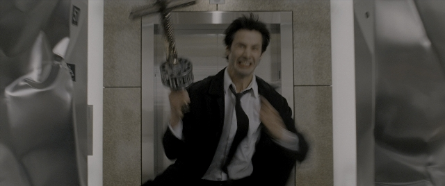 Wide shot frame from Constantine — sitting, door, hand