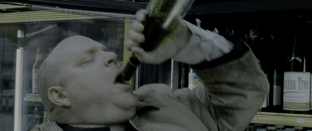 Wide shot frame from Constantine — standing, bottle, face