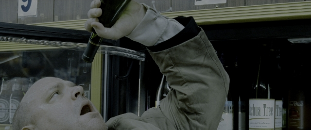 Wide shot frame from Constantine — hand, bottle, person