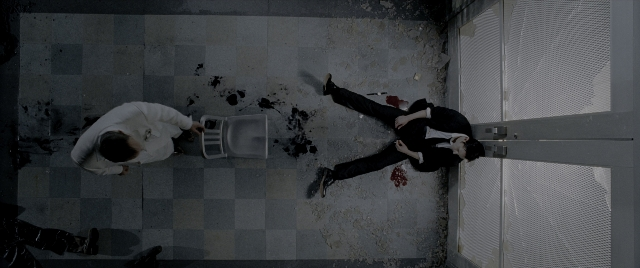 Wide shot frame from Constantine — door, suit, tie