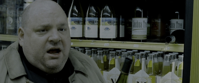 Medium shot frame from Constantine — standing, bottle, face