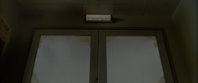 Wide shot frame from Constantine — room, door, glass